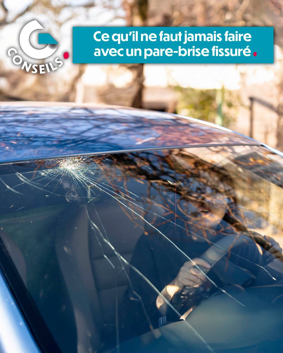 Voiture avec le pare-brise fissuré sous un message d’avertissement