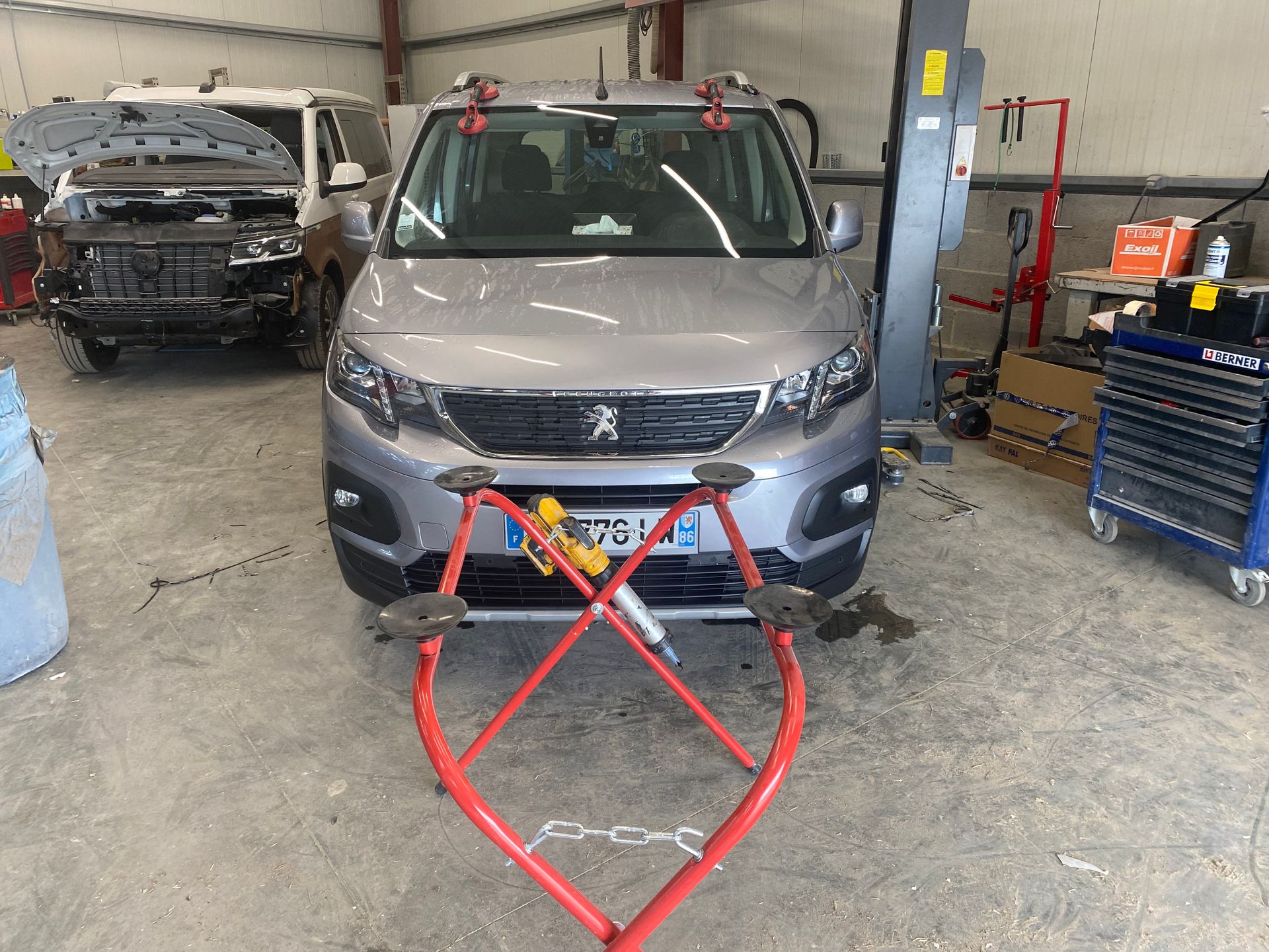 Pose de pare-brise en plan large sur voiture grise