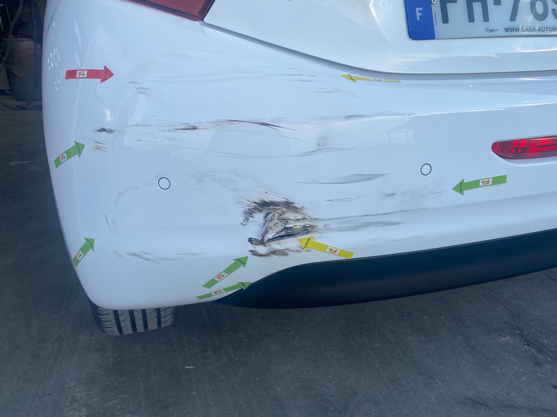 Arrière de voiture blanche avec rayures et marquages