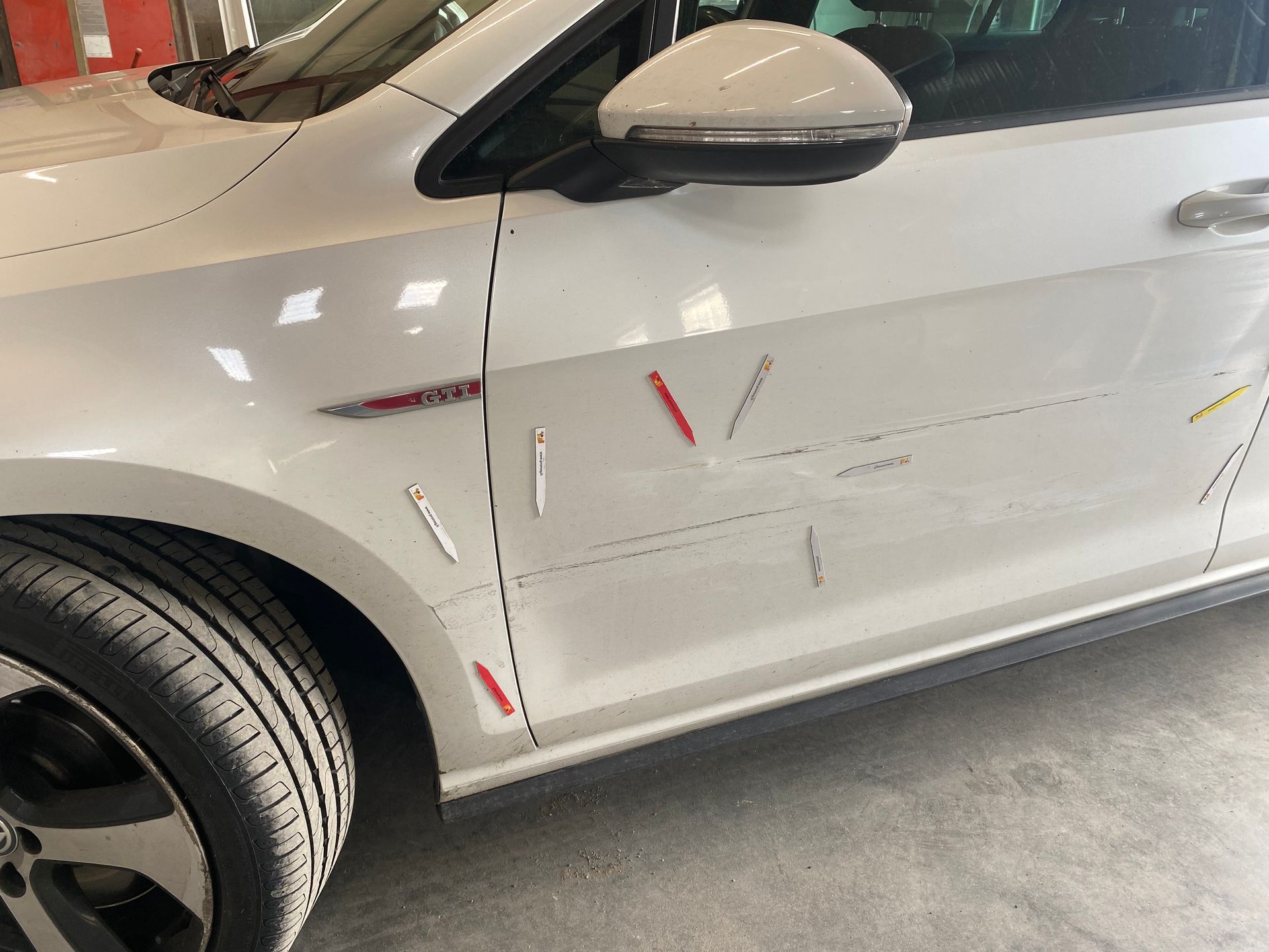 Voiture blanche de profil marquée par des flèches de couleurs