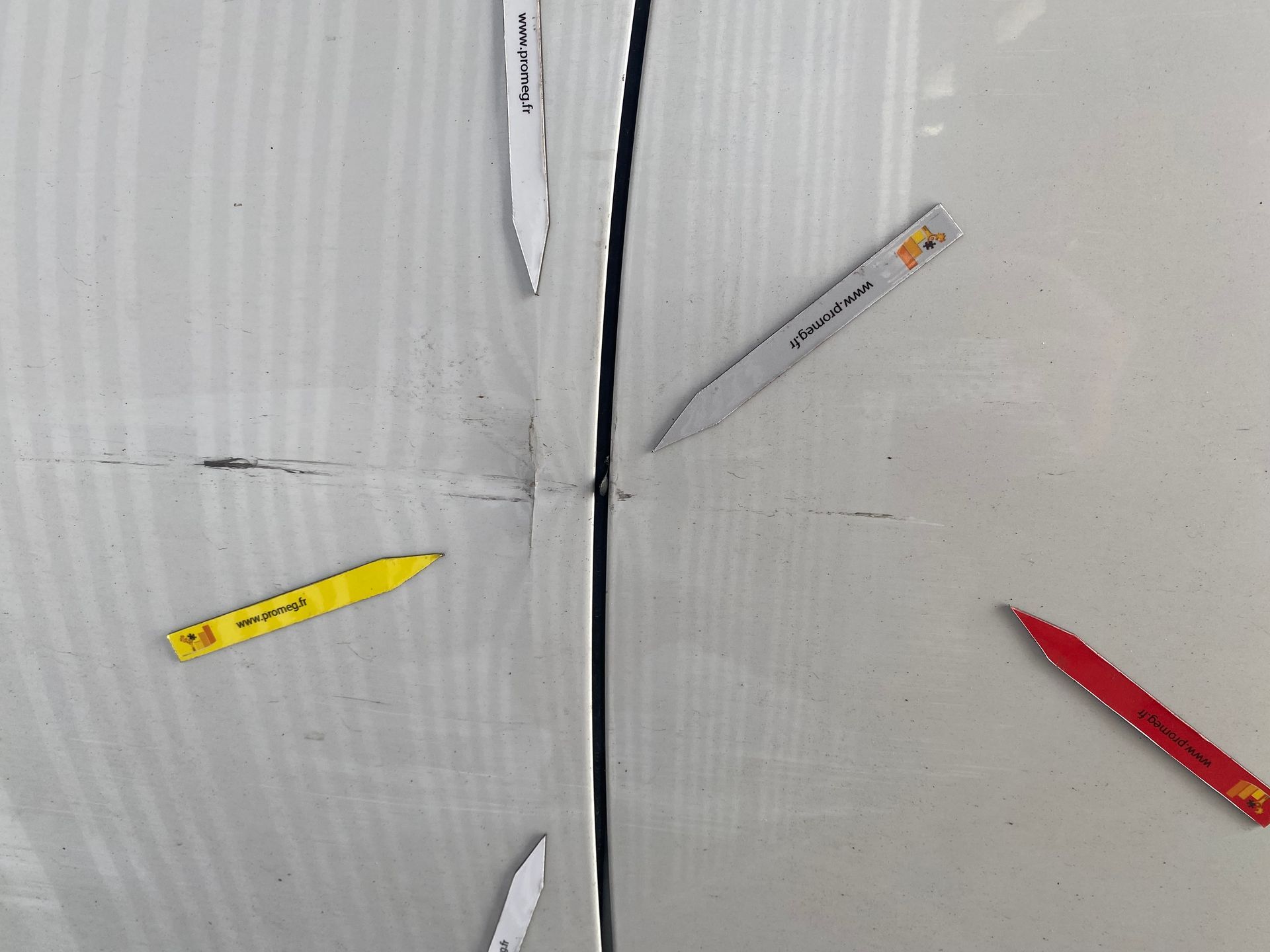 Carrosserie gris clair marquée par des flèches