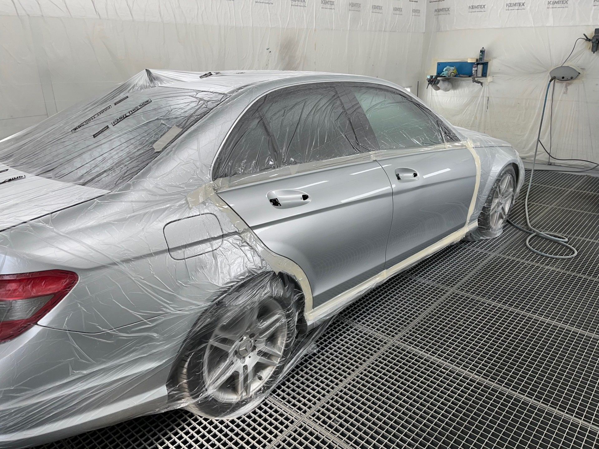 Voiture grise prête pour être repeinte sous bache