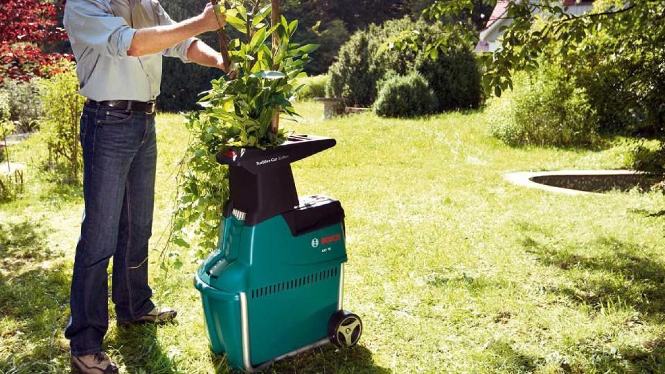 Broyeur de végétaux compact utilisé par un homme dans son jardin