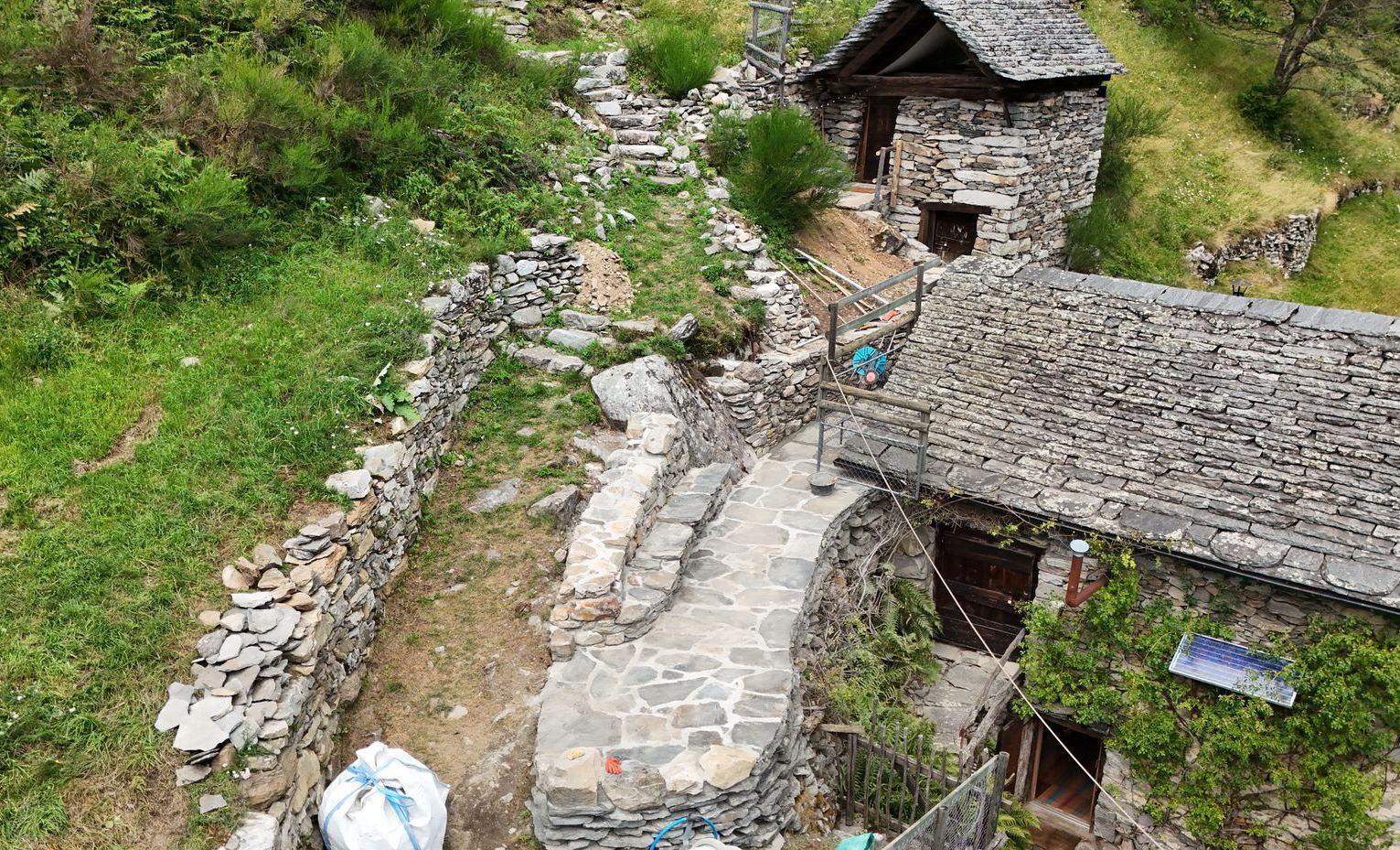 Un sentiero erboso delimitato da un muro di pietra.