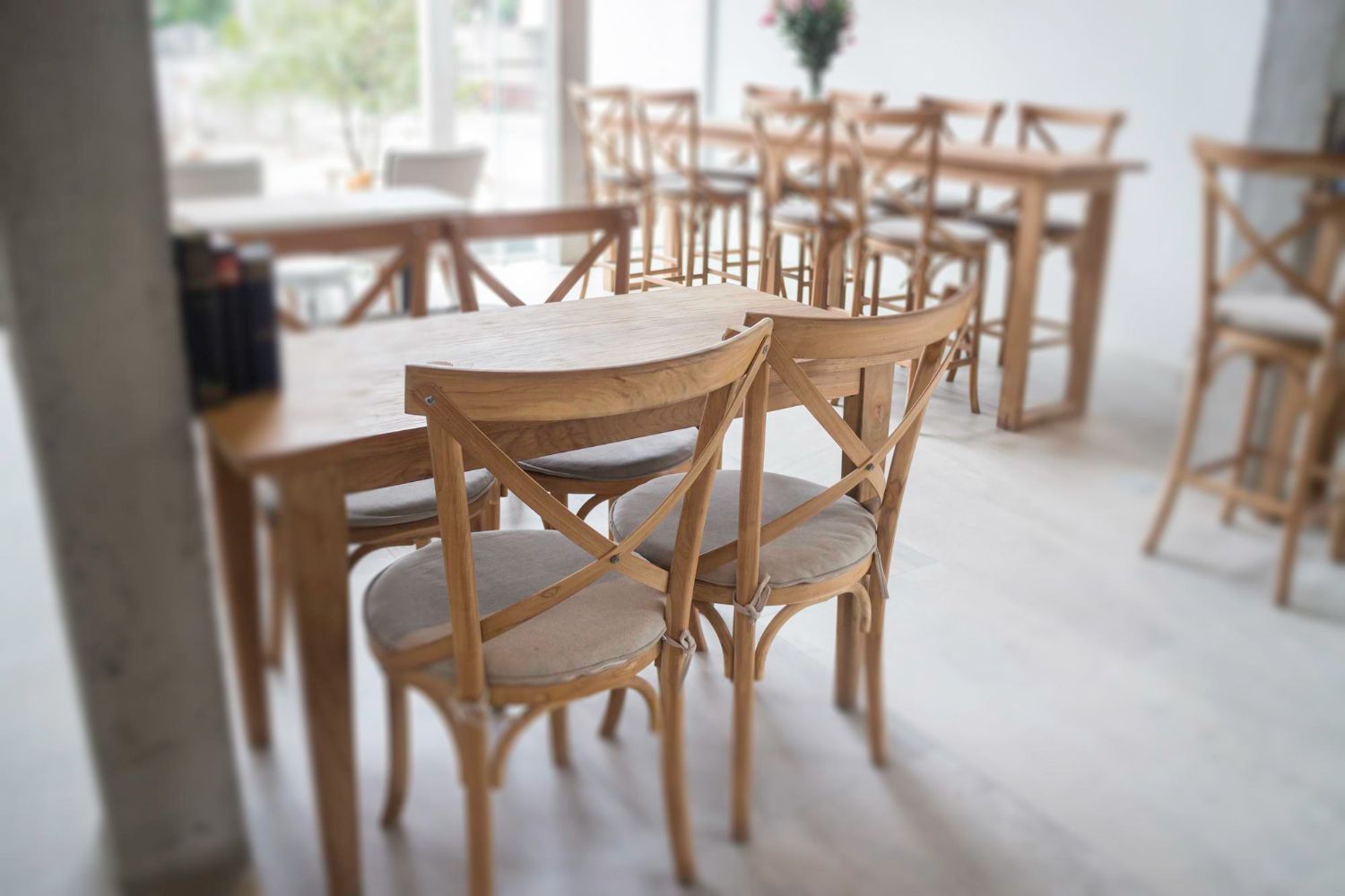 Mesas y sillas de madera en un interior luminoso y espacioso.
