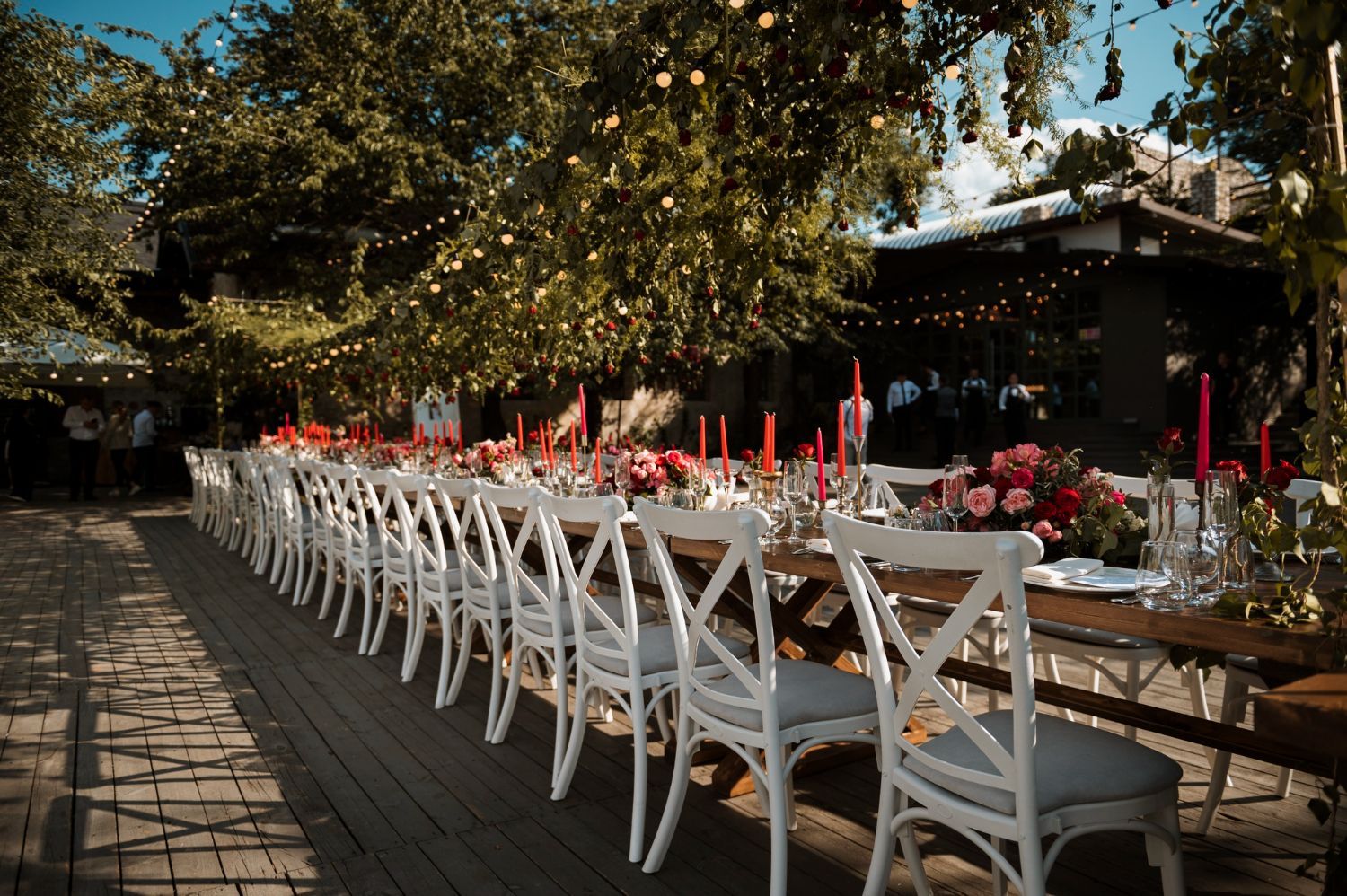 Recepción de boda al aire libre con mesa larga preparada para los invitados;