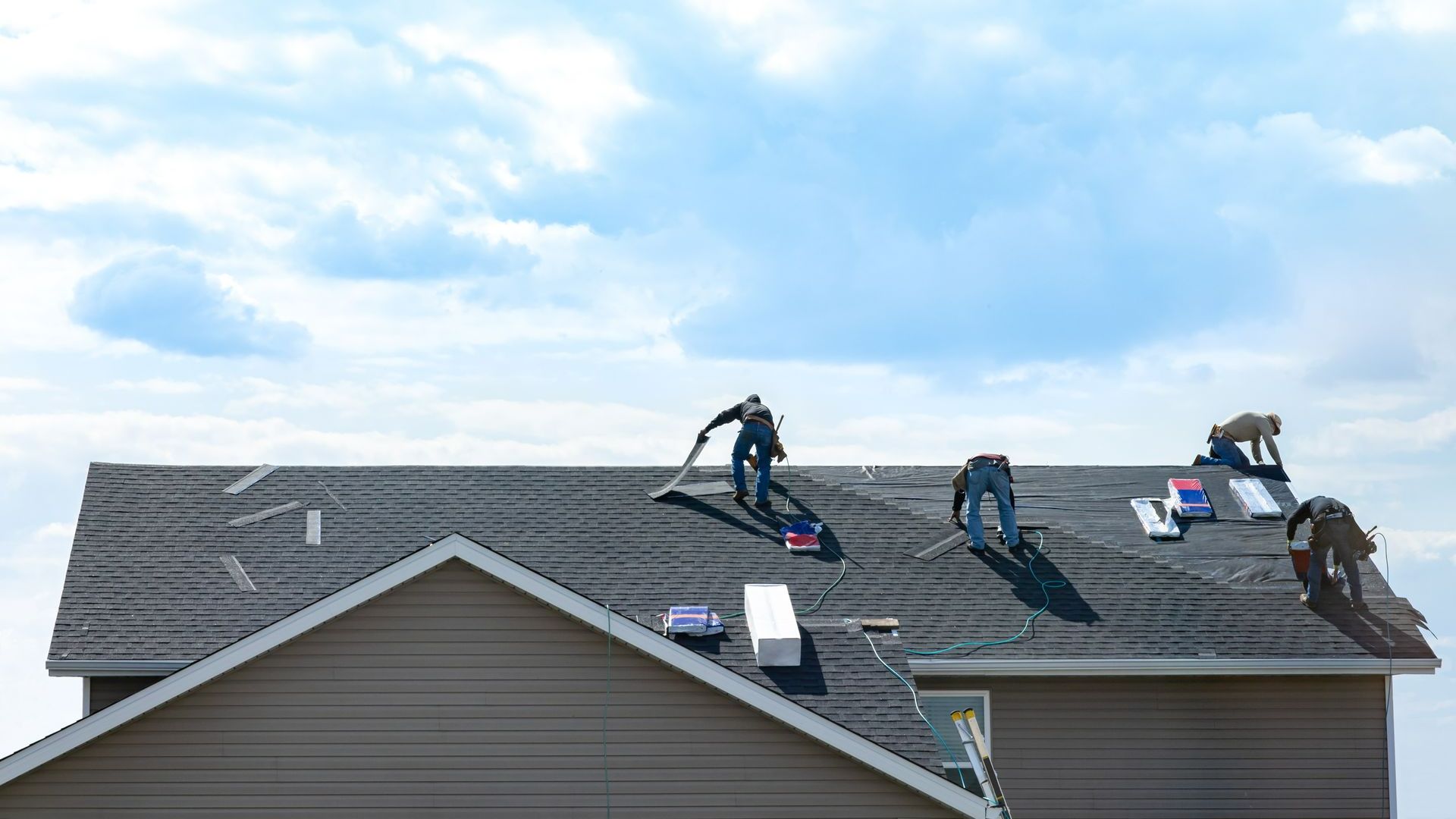 Quatre couvreurs sur un toit