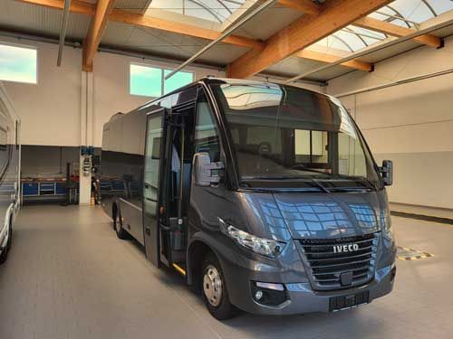 Das Innere eines Busses mit grünen Sitzen und gelben Kopfstützen.