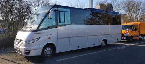 Das Innere eines Busses mit grünen Sitzen und gelben Kopfstützen.