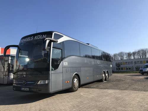 Ein Mingels-Bus steht vor einem Gebäude.