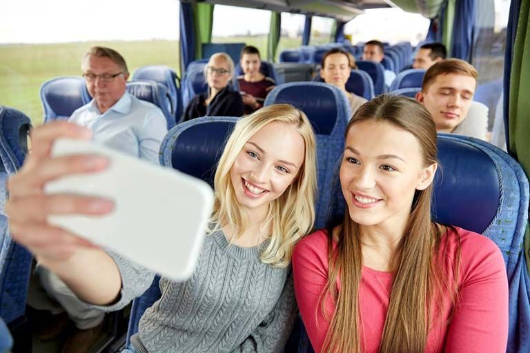 Eine Gruppe von Leuten macht in einem Bus ein Selfie.