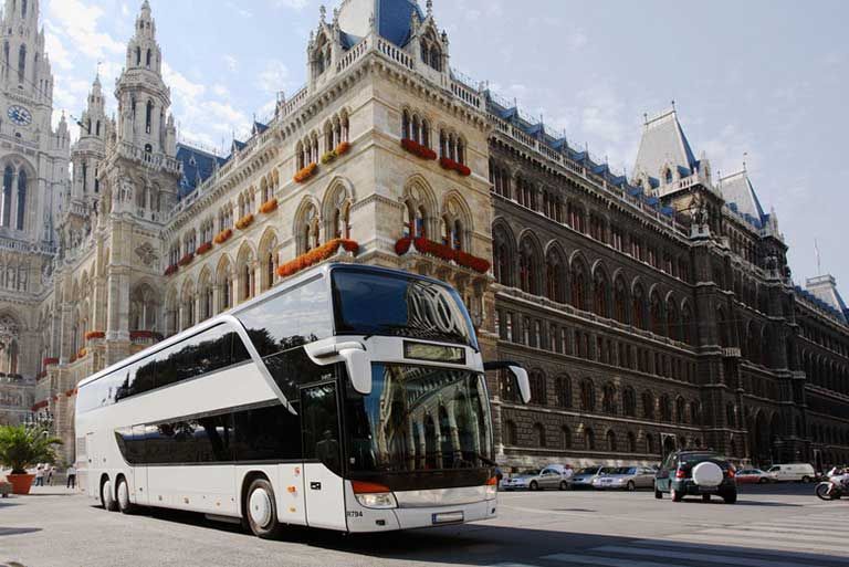 Ein Doppeldeckerbus steht vor einem großen Gebäude