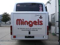 Das Heck eines Mingels-Busses steht auf einem Parkplatz.