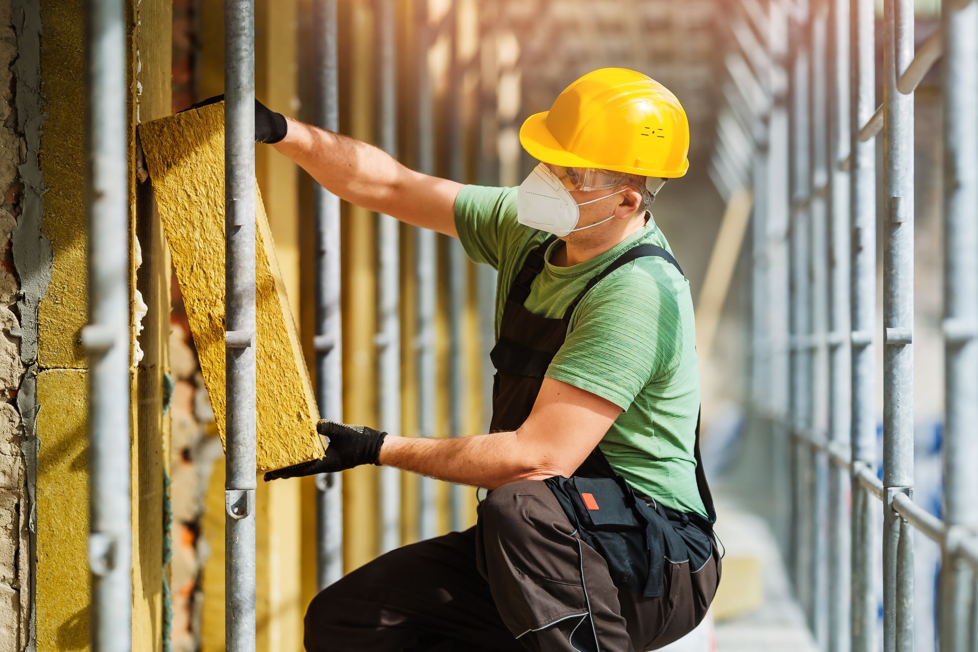 Artisan posant de l'isolant sur une façade