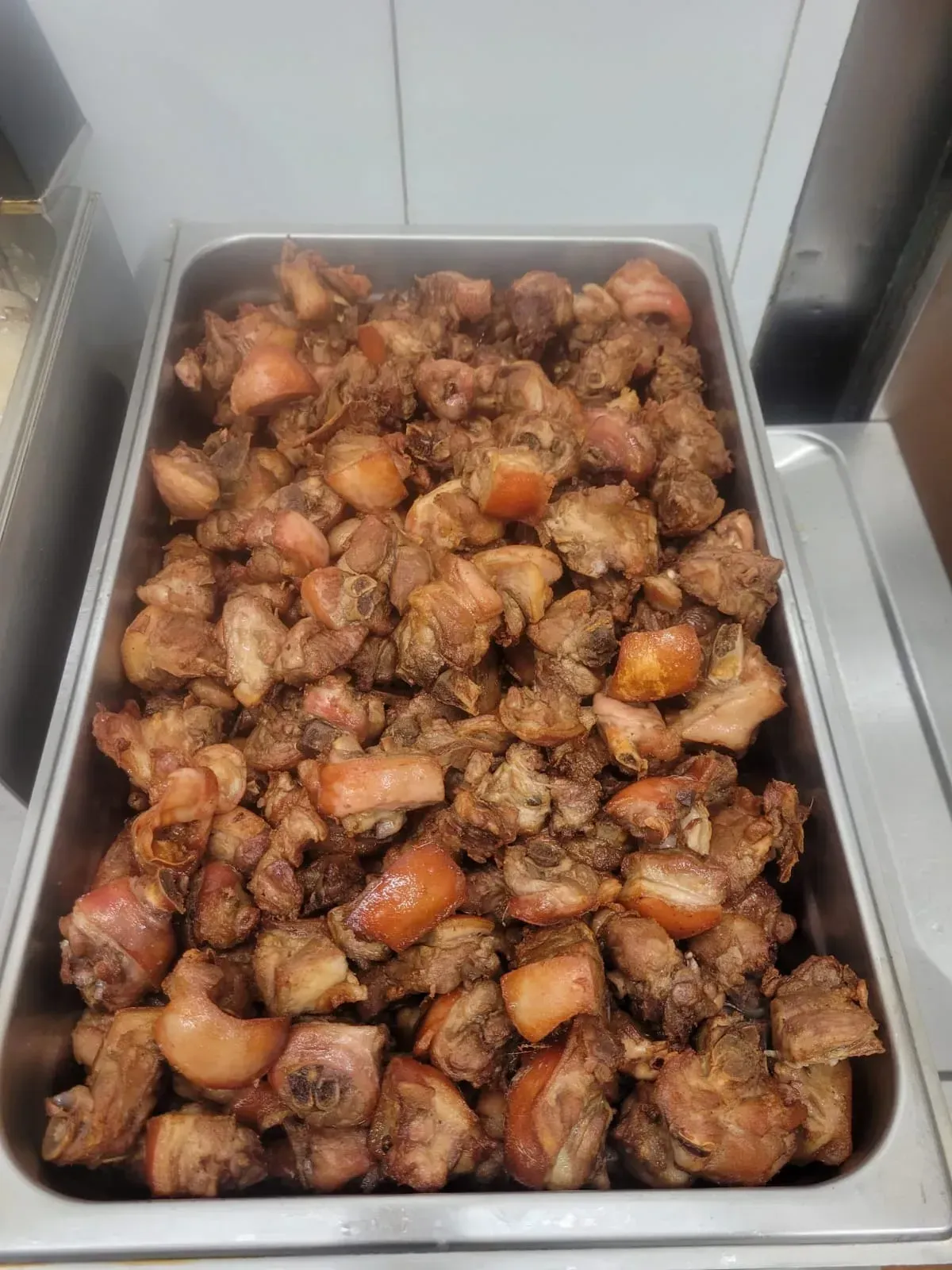 Bandeja llena de trozos de cerdo cocidos.