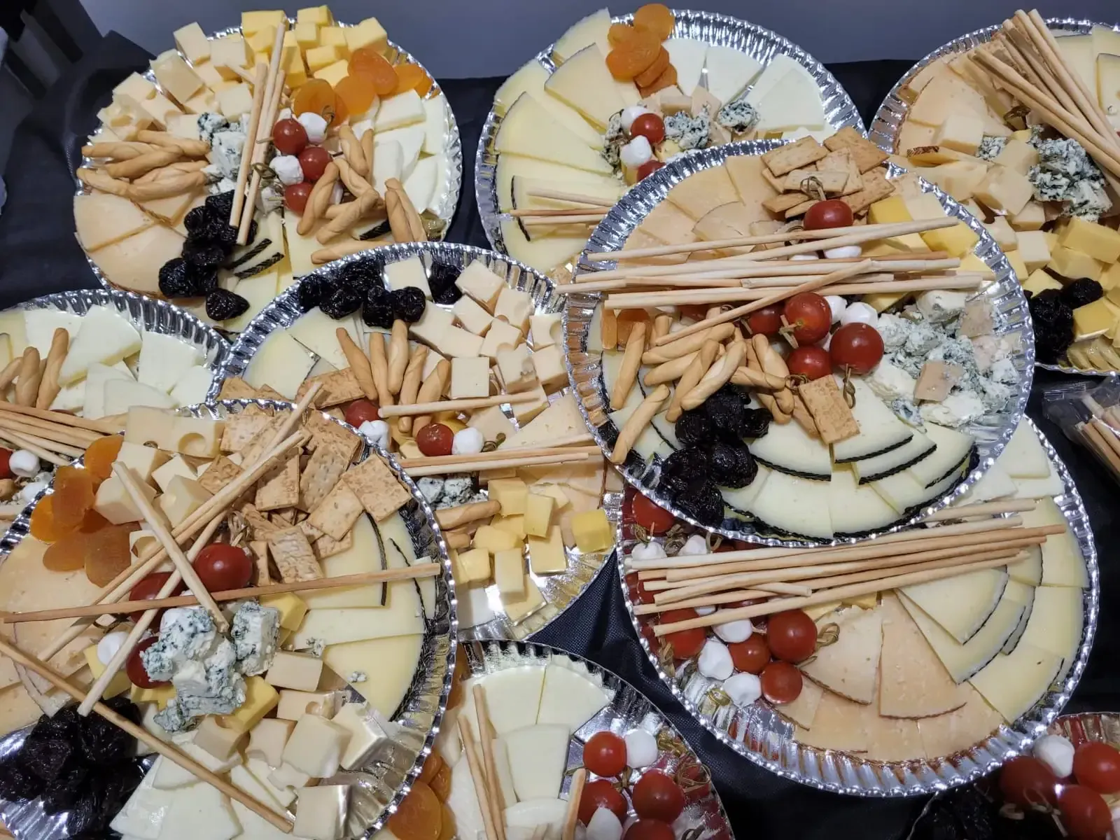 Platos de quesos variados con galletas, frutos secos y uvas.