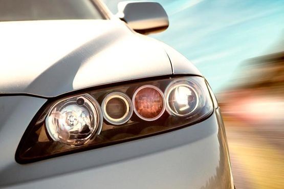 Un primer plano de los faros de un coche blanco.