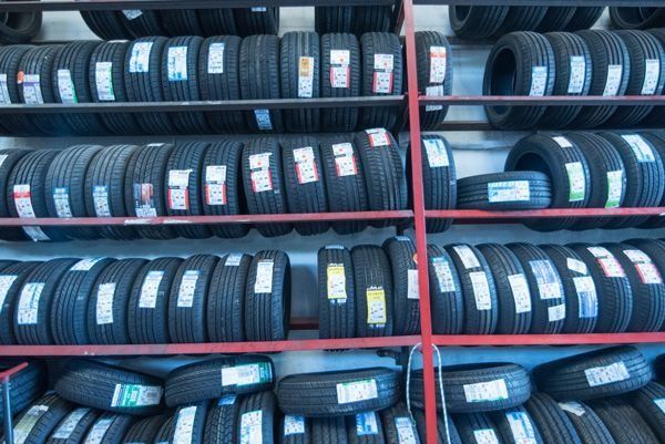 Un montón de neumáticos están apilados uno encima del otro en un estante.