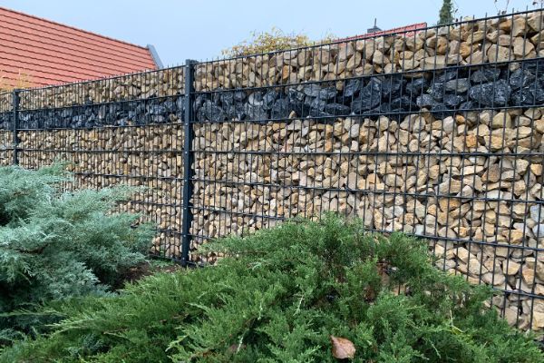 Gabionenzaun mit braunen und schwarzen Steinen