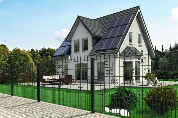 Stahlzaun vor einem Haus mit Garten