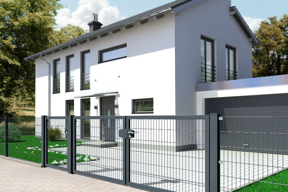 Gitterzaun mit Zweiflügel-Tor vor einem Haus