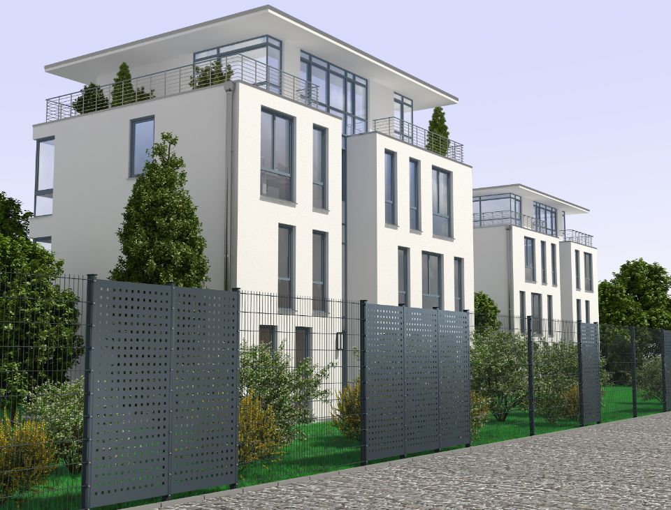 Gitterzaun mit Sichtschutzelementen vor einem Haus mit Garten