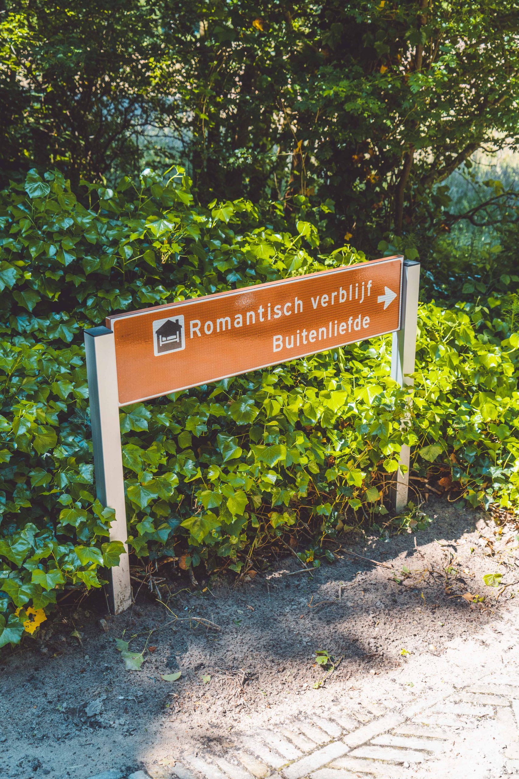 Wegwijzer met bruin bord en witte tekst: 