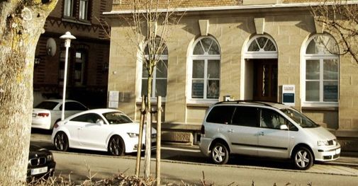 Außenansicht eines Hauses mit zwei parkenden Autos davor