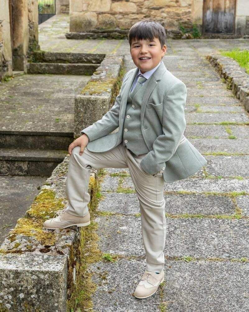 Un niño sonriente, vestido con un traje