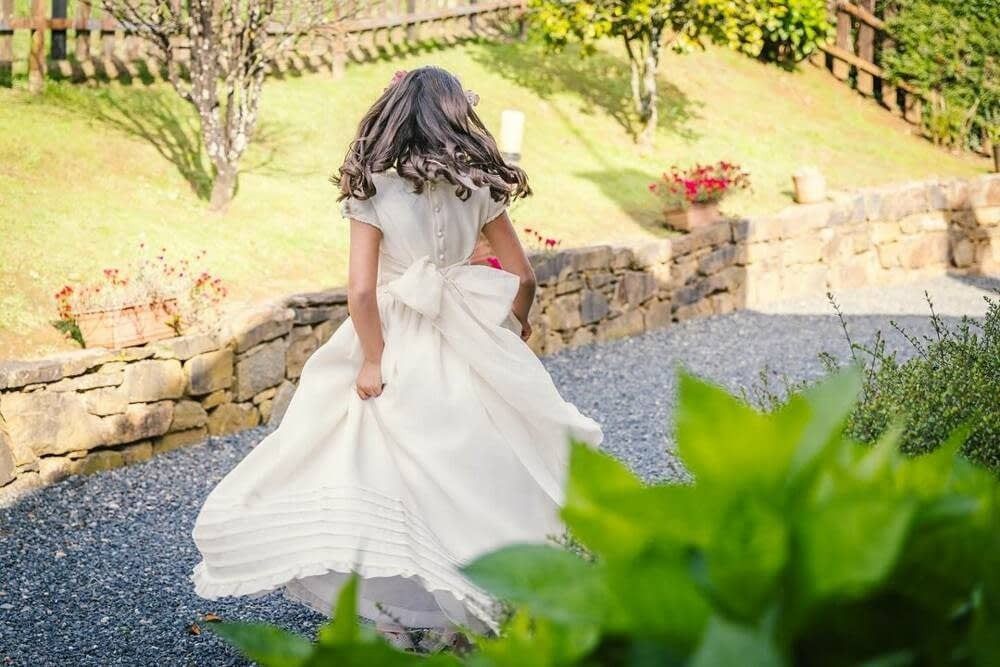 Una persona con un vaporoso vestido blanco da vueltas sobre un sendero 