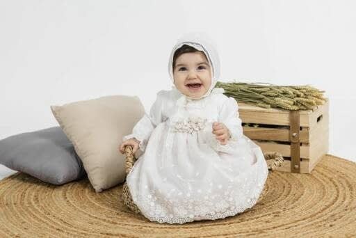 Un bebé con un vestido y un gorrito