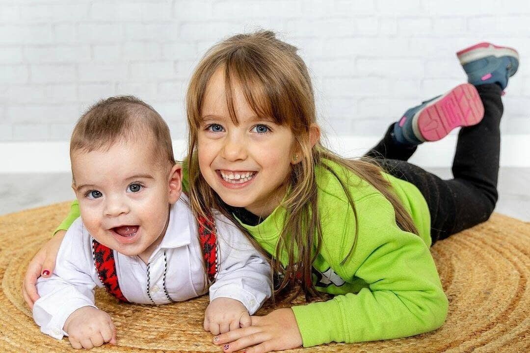 Un niño sonriente con un suéter verde