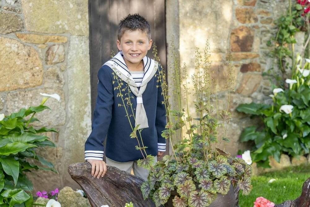 Un niño sonriente, vestido con un traje