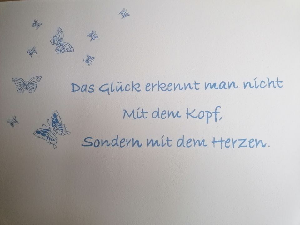 Weiße Karte mit blauen Schmetterlingen und Text: „Glück erkennt man nicht mit dem Kopf, sondern mit dem Herzen.“