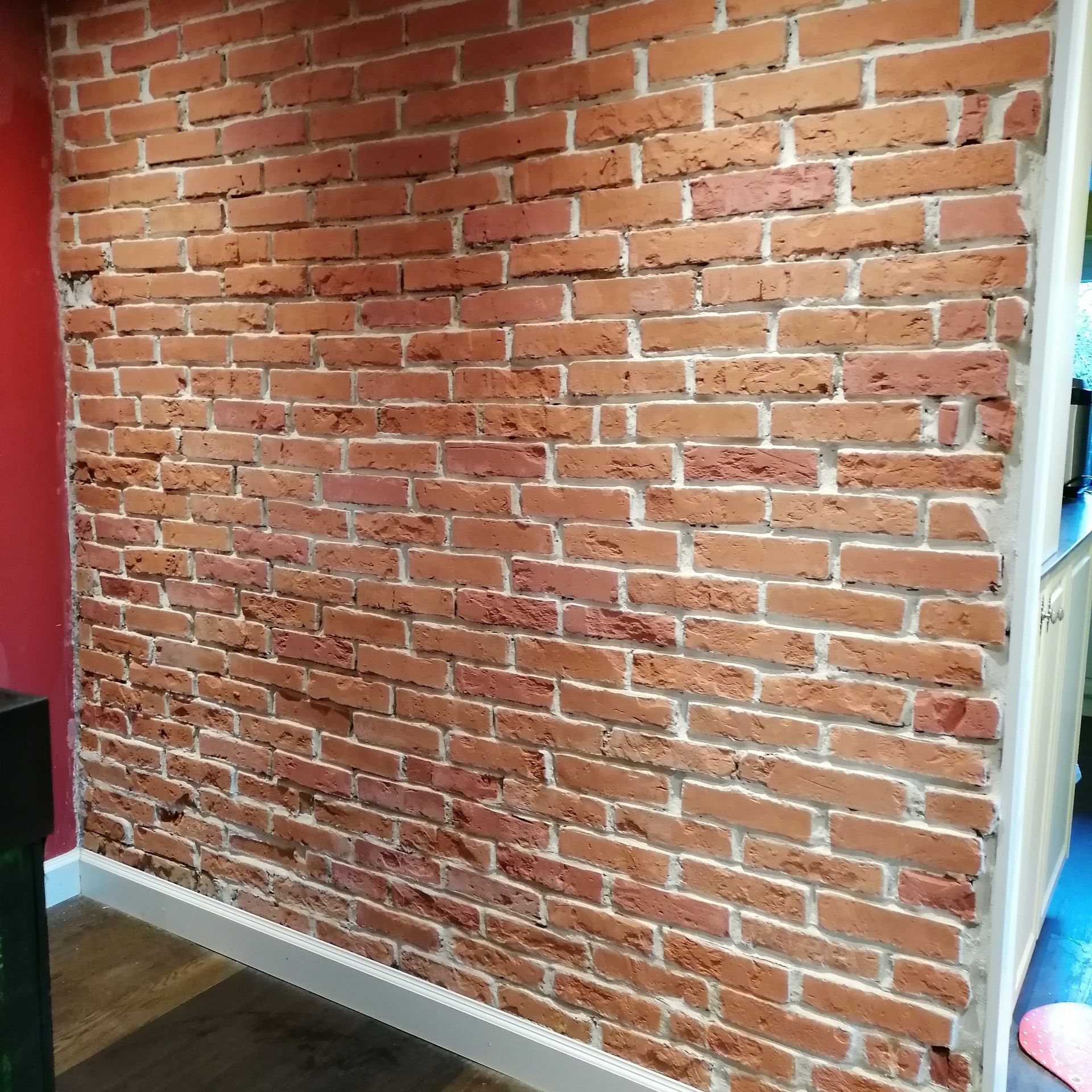 Ziegelmauer mit weißem Mörtel, roten und braunen Ziegeln.