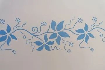 Blaue florale Rankenschablone auf weißem Hintergrund.