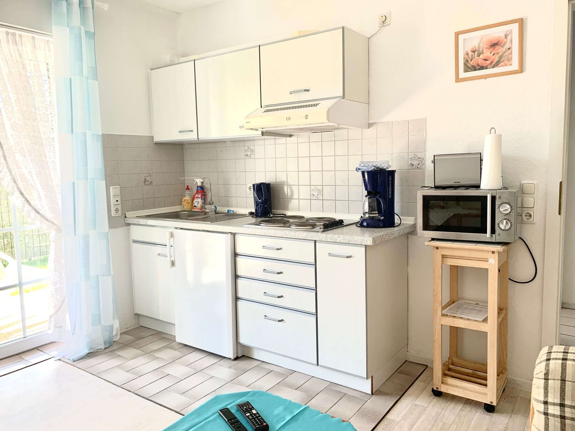 Ferienwohnung Bernstein im Haus Aquamarin in Büsum – Küchenzeile mit Mikrowelle, Kaffeemaschine, Wasserkocher und 4-Zonen-Kochfeld