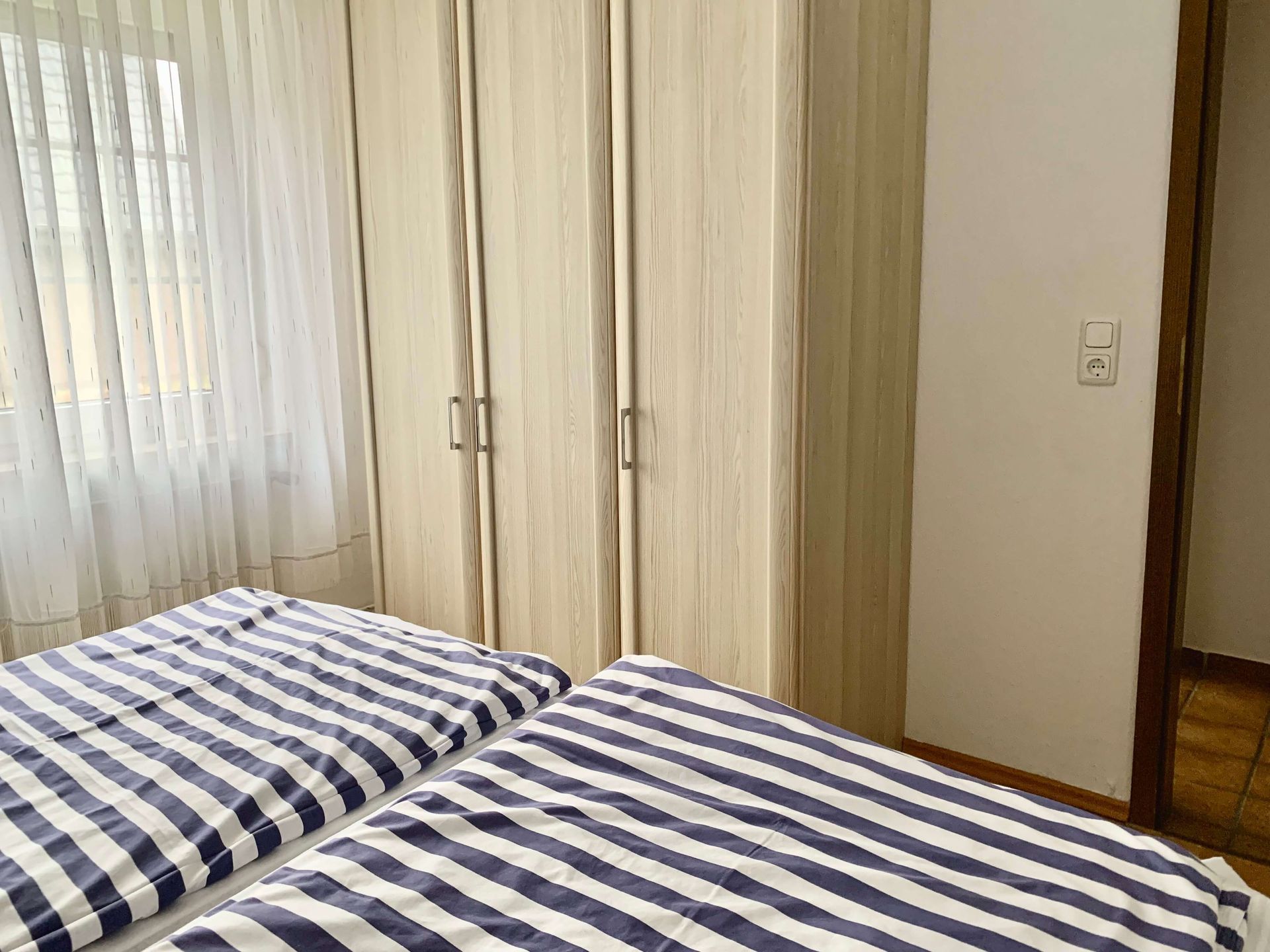 Ferienwohnung Rubin im Haus Aquamarin in Büsum – Schlafzimmer mit Doppelbett und großem Kleiderschrank