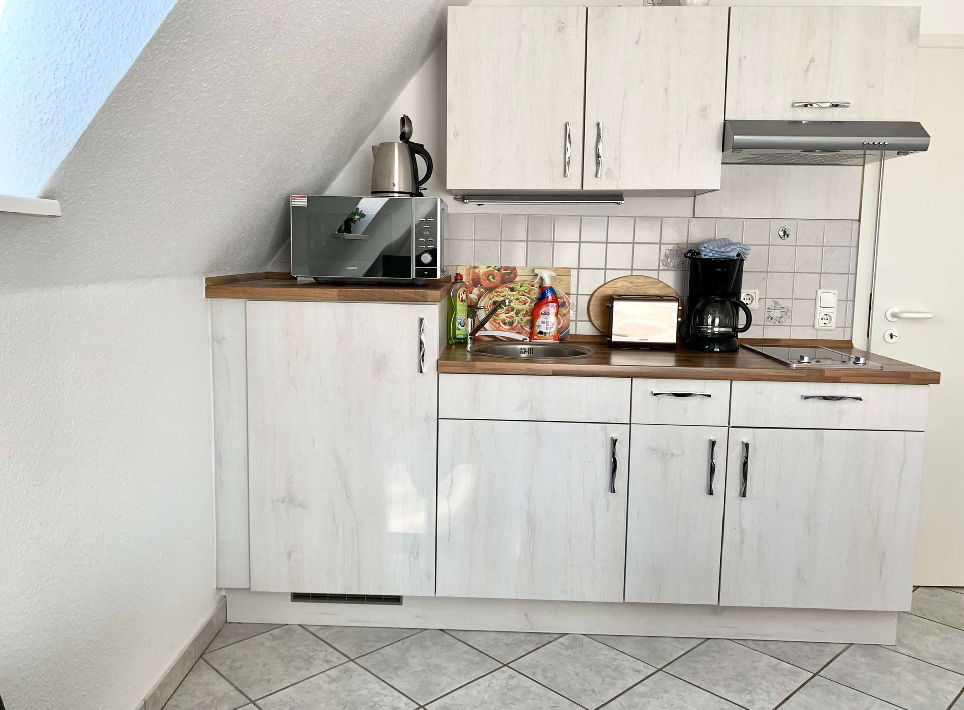 Studio-Apartment Smaragd im Haus Aquamarin in Büsum – Küchenzeile mit Spüle und Kaffeemaschine