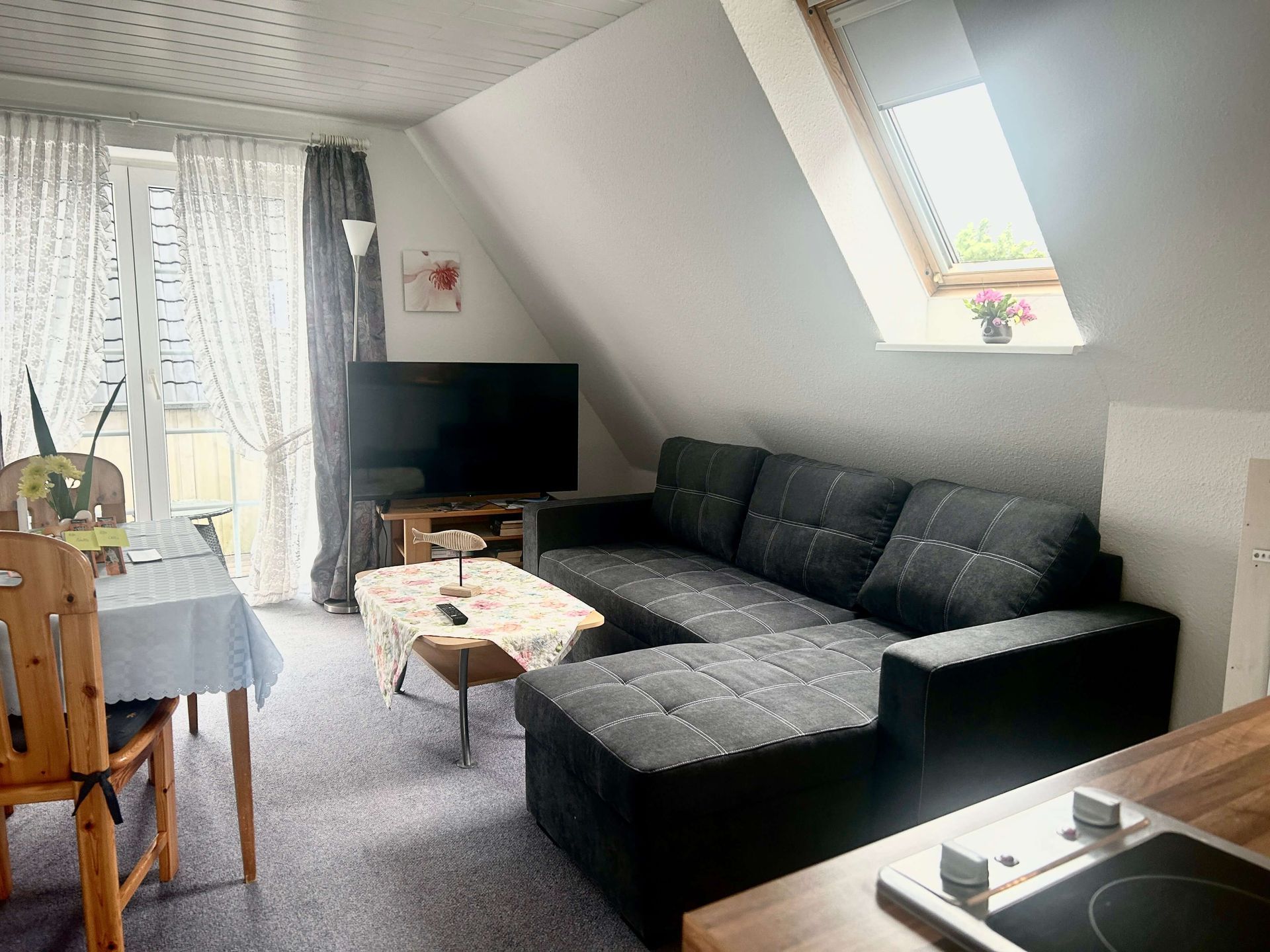 Studio-Apartment Smaragd im Haus Aquamarin in Büsum – Wohnbereich mit Sofa, Smart-TV und Balkonzugang