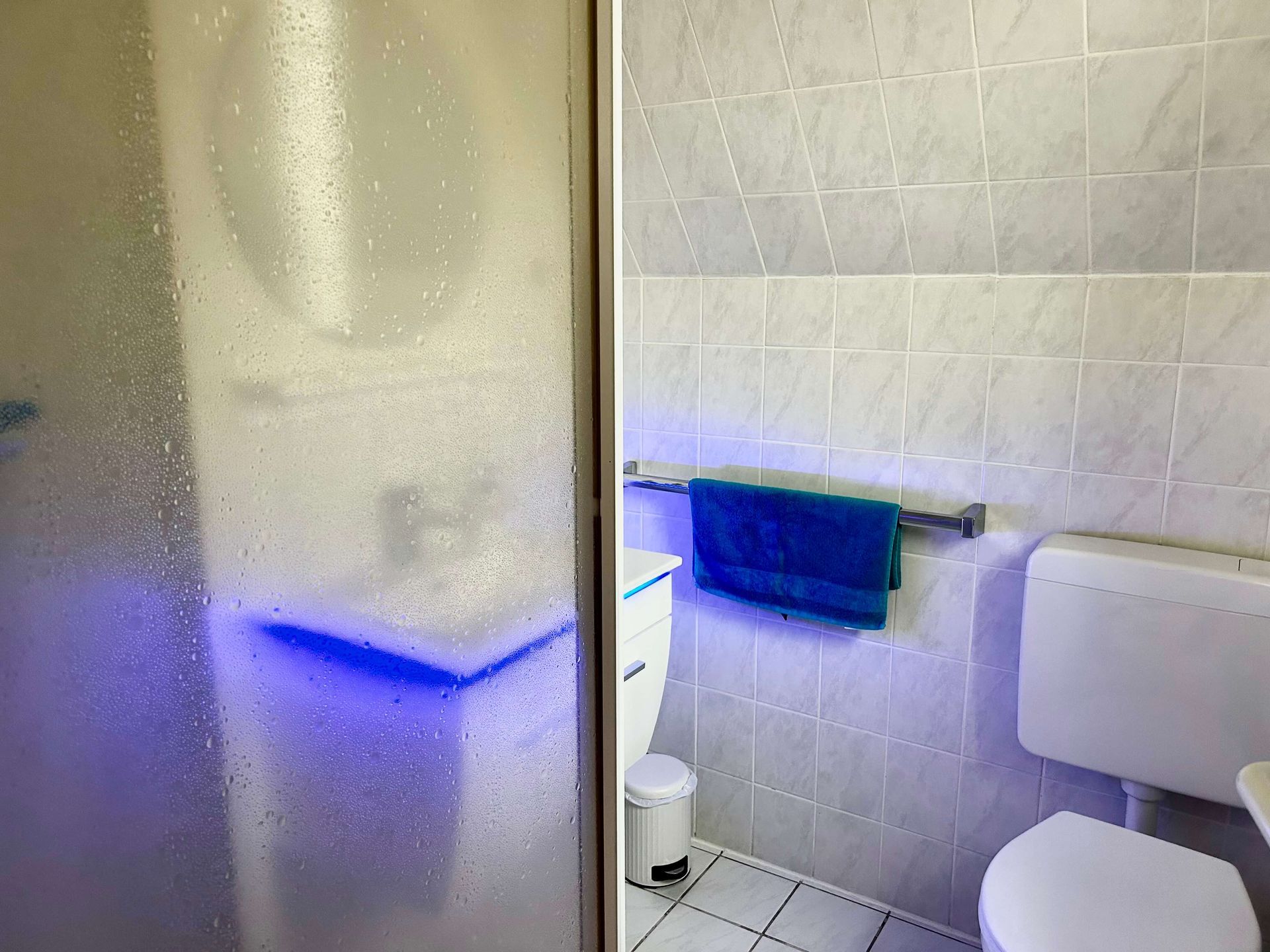 Studio-Apartment Smaragd im Haus Aquamarin in Büsum – Badezimmer mit Waschtisch und blauer Beleuchtung