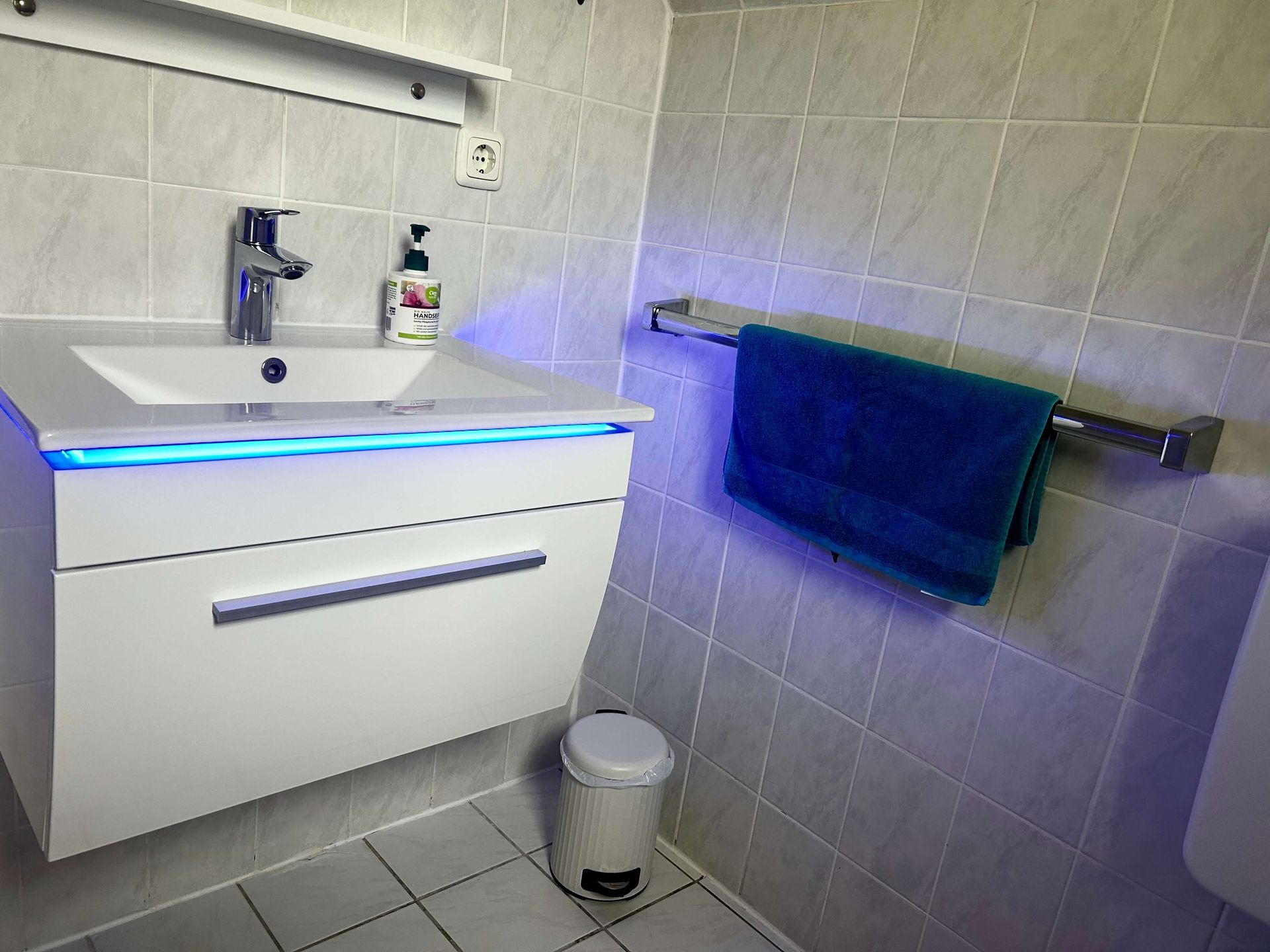 Studio-Apartment Smaragd im Haus Aquamarin in Büsum – Badezimmer mit Waschtisch und blauer Beleuchtung