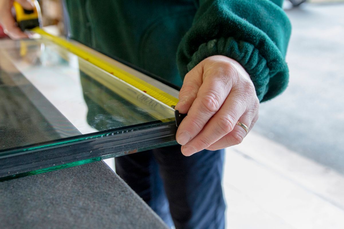Professionnel prenant des mesures sur du verre.