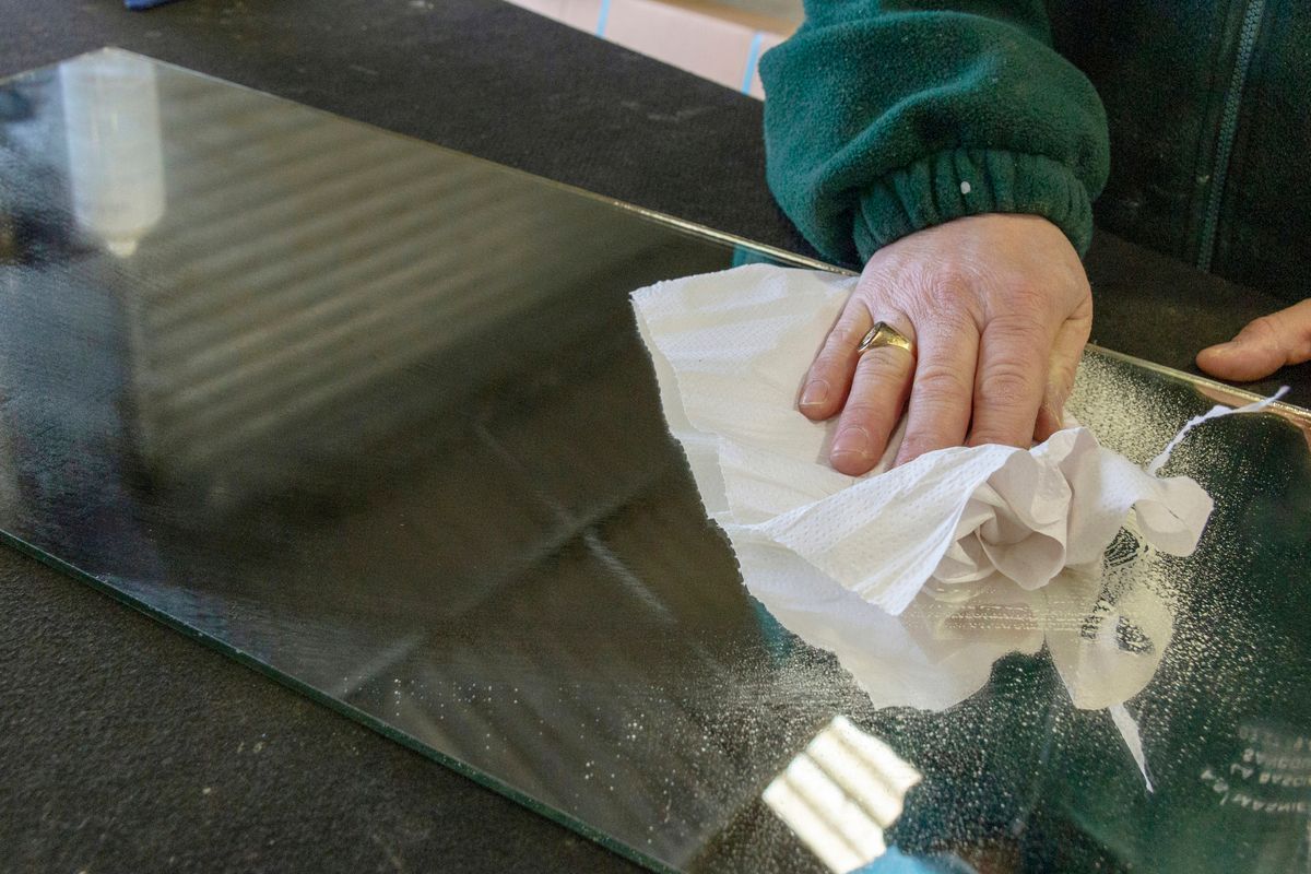 Personne passant un chiffon sur une vitre.