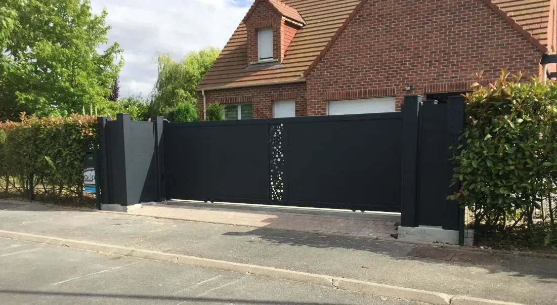 Portail noir devant une maison.