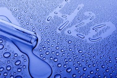 Se utiliza una pipeta para medir una gota de líquido sobre una superficie azul.
