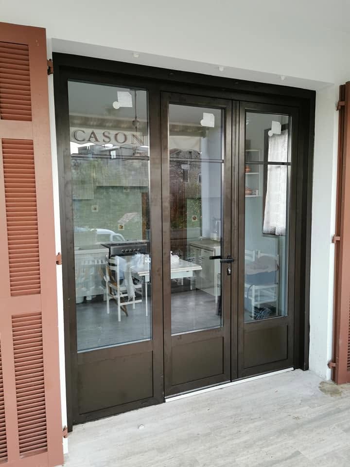 Une maison contemporaine avec une terrasse, du mobilier de jardin et un balcon par une journée ensoleillée.