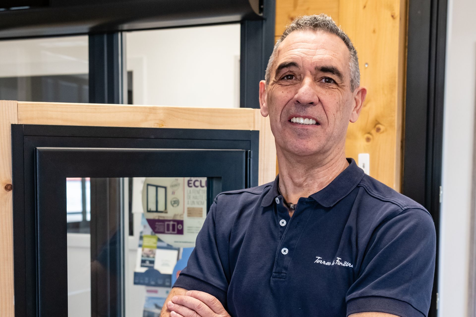 Un cinquième homme souriant croisant ses bras de chez Artprobat.