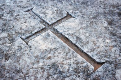 Croix sculptée dans de la pierre patinée.