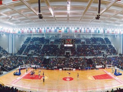 Se está jugando un partido de baloncesto en un estadio grande.